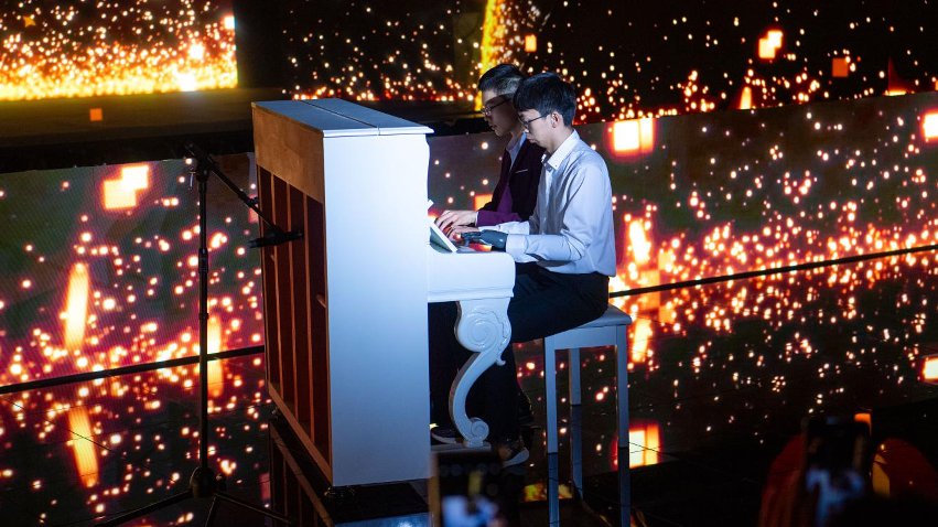 智能仿生手使用者古月與少年鋼琴家舒海峰合奏。主辦方供圖