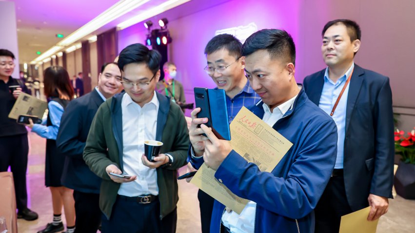 人民網(wǎng)研發(fā)推出的《人民日報(bào)》生日報(bào)吸引嘉賓體驗(yàn)。主辦方供圖