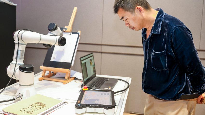 嘉賓體驗(yàn)遨博AI繪畫機(jī)器人。主辦方供圖